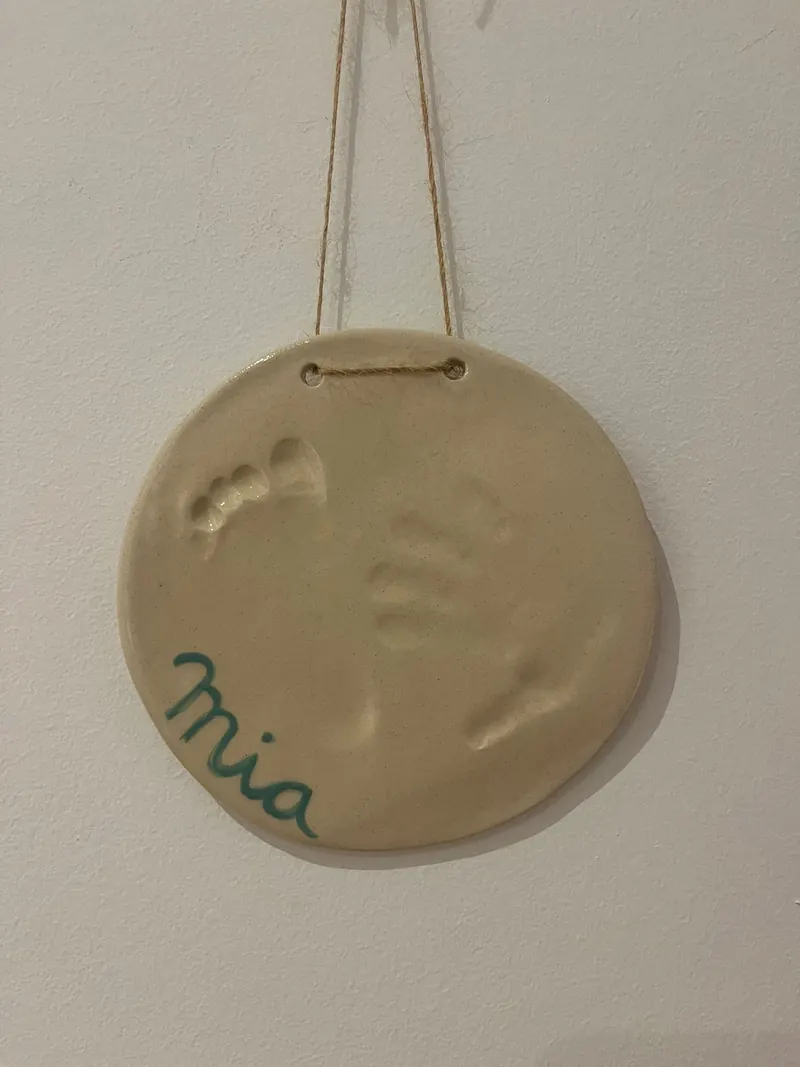 Placa redonda de cerámica con la huella de un bebé y el nombre Mia